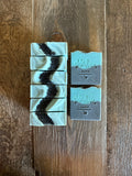 Black and blue soaps with black sea salts on top.