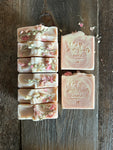 Image shows a group of pink and white soaps with dried flowers on top.