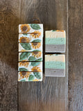 Brown, green and white soaps with sunflowers and leaves on top made out of glycerin soap.