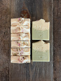 White and green soaps with flower petals on top.
