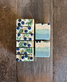 Blue, green and white soaps with glycerin soap blueberries and leaves on top.